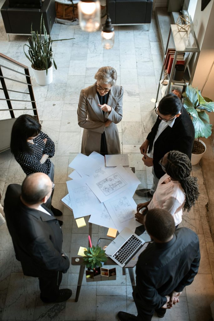 pexels-photo-5922201-5922201 A diverse group of professionals collaborating over documents in a modern office setting.